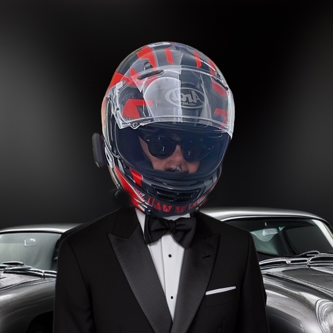 Mathieu Barthélémy en smoking et casque intégral devant deux Aston Martin DB5